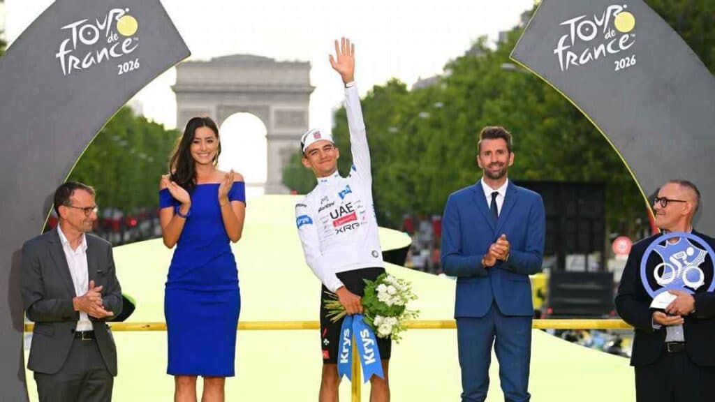 Isaac del Toro en el podio del Tour de Francia 2026, celebrando su tercer lugar junto a otros presentadores y el Arco del Triunfo al fondo.