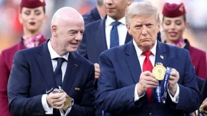 Gianni Infantino y Donald Trump sostienen medallas durante un evento, mientras otros asistentes los observan con interés.