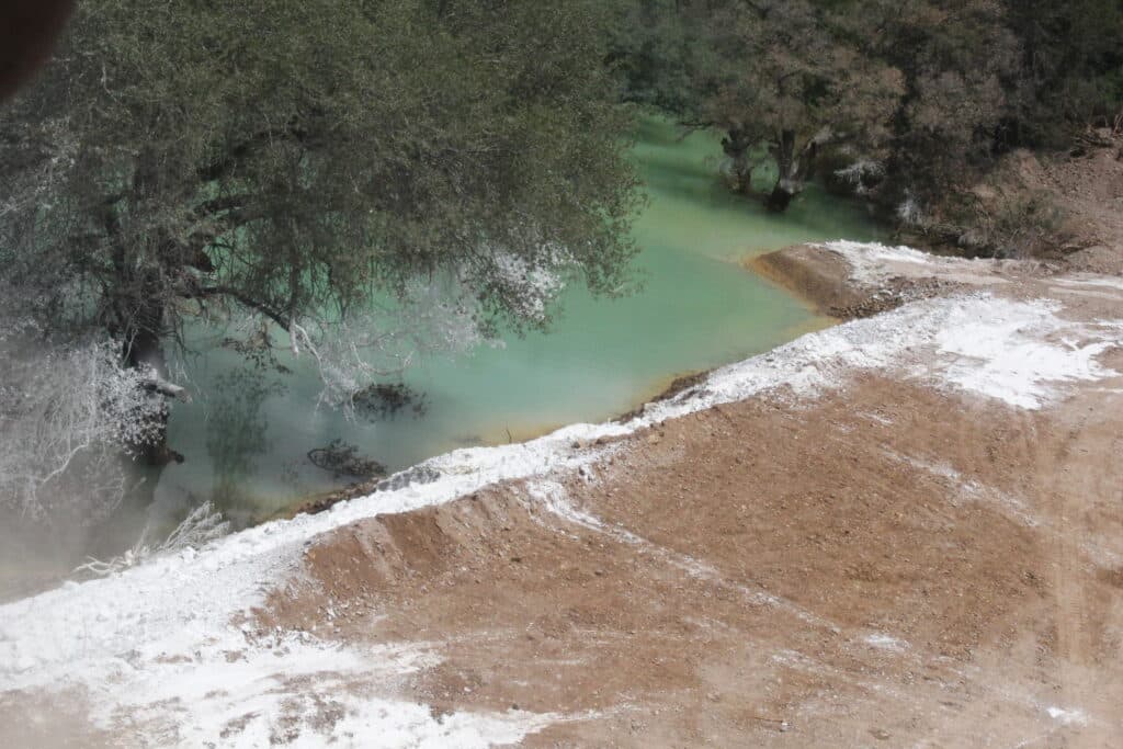 Contaminación visible en el Río Sonora, con aguas turquesa y sedimentos blancos, evidenciando el impacto del derrame de Grupo México.
